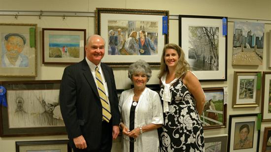 First place (professional category) winner Mona Kirk of Manasquan iis congratulated by Monmouth County Freeholder Director John P. Curley (left) and Freeholder Serena DiMaso (right) for her watercolor entitled “The Gossippers.”